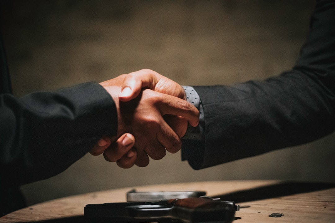 Conversiegerichte website laten maken: handdruk over een houten tafel staat voor een geslaagde aanvraag