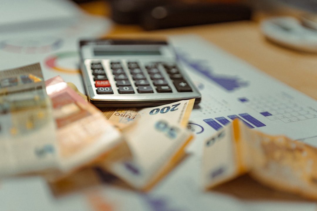Besparen op maandelijkse kosten website: calculator op een stapel geld